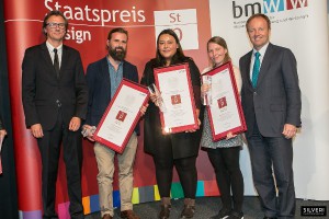 Gewinner des Staatspreises Design „Räumliche Gestaltung“ ist das „magdas Hotel – Hotelkonzept“ von AllesWirdGut ZT GmbH (Friedrich Passler, Johanna Aufner, Andrea Zuñiga Espinoza), flankiert von Prof. (FH) Dipl. Des. Michael Lanz (l.) und Dr. Michael Losch. © Silveri für bmwfw